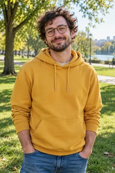 Input photo for Closed on Sunday AI example 2: a man with curly hair and round glasses in a mustard-yellow hoodie (AI-generated sample person)